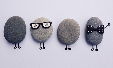 Four pebbles dressed as people you might find in an office