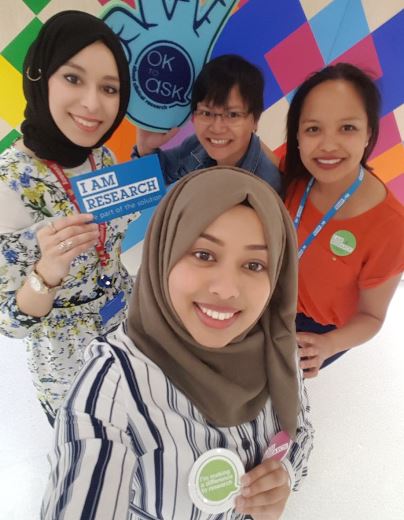 Smiling young ladies with 'I am research' badges